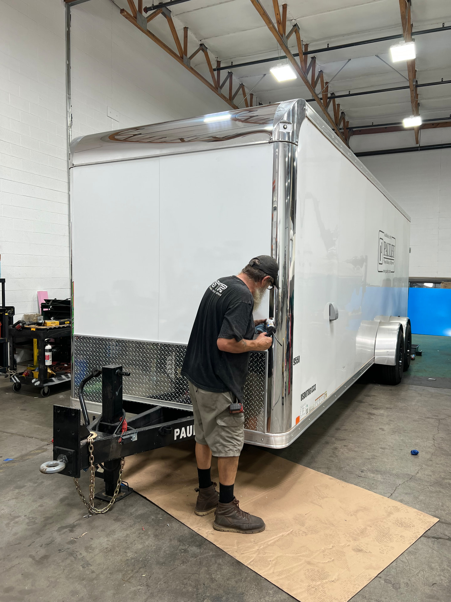 SPARKS technician polishing an enclosed cargo trailer after panel and trim work