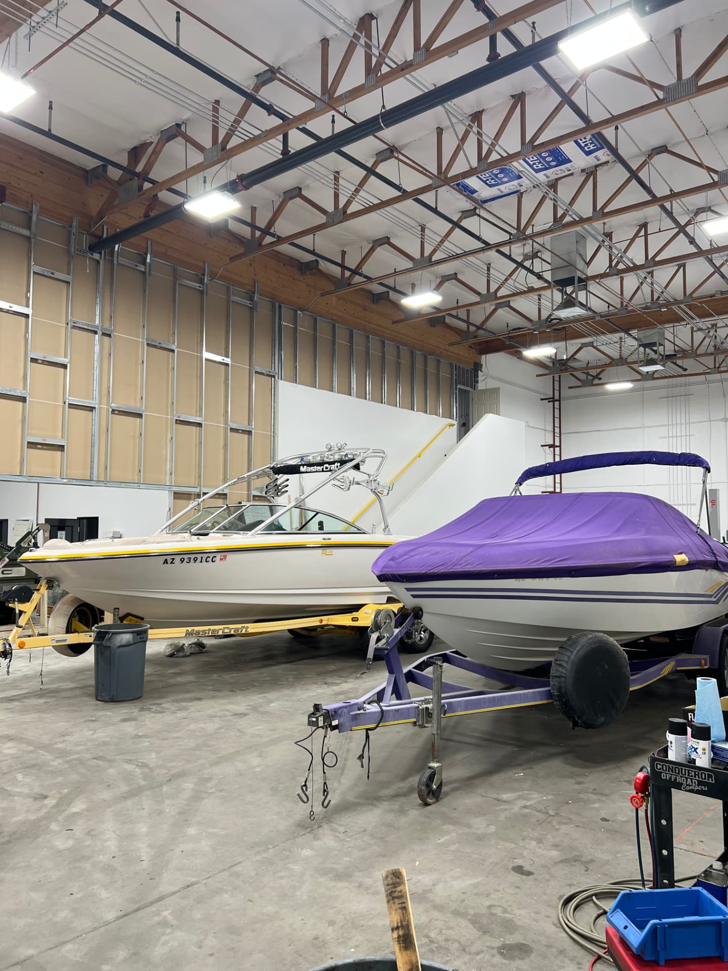 Boats on trailers inside the SPARKS Trailer Repair indoor 10,000 sq ft facility in Gilbert, AZ