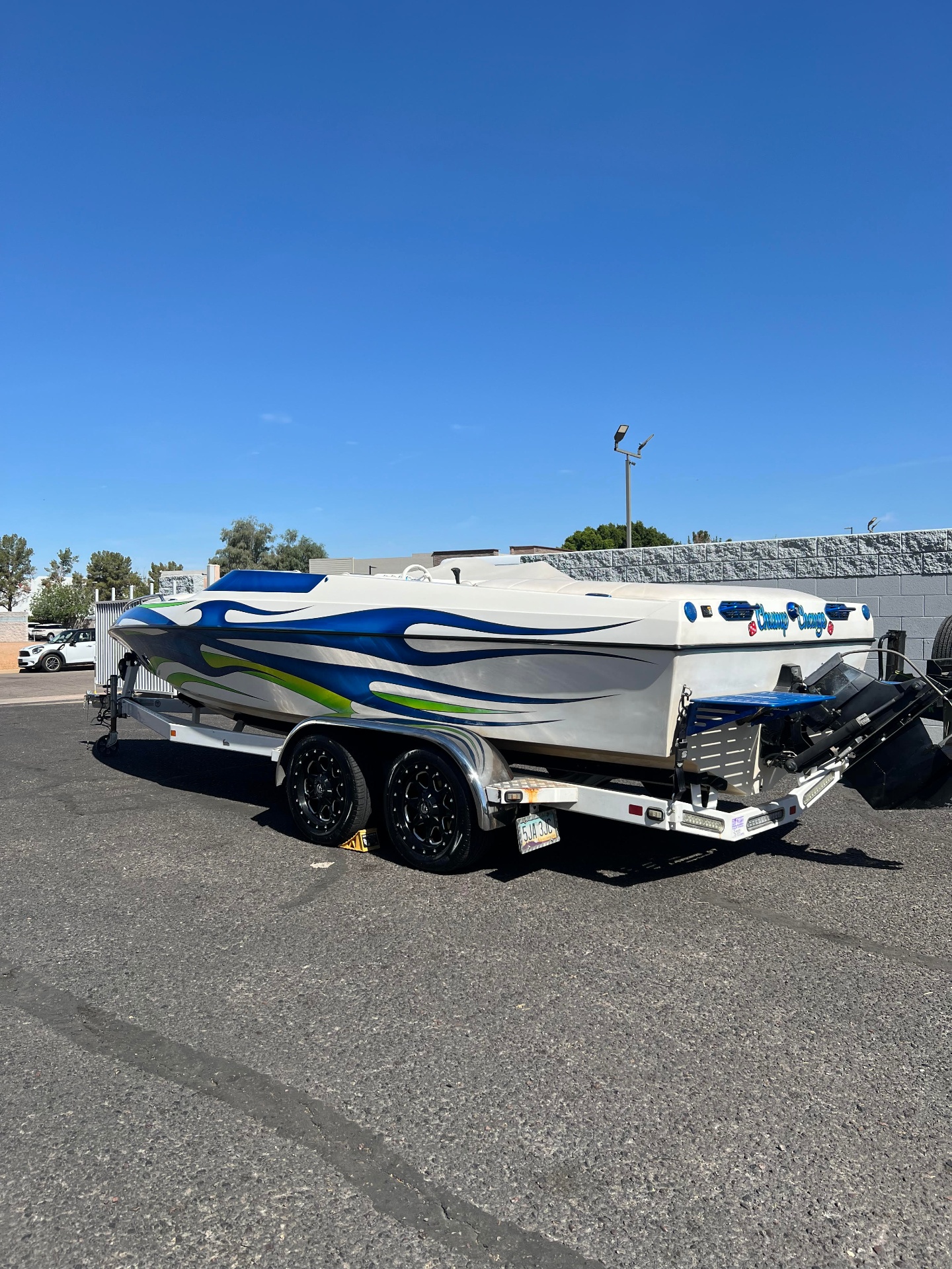 Custom wrapped speedboat on tandem trailer after bearing service